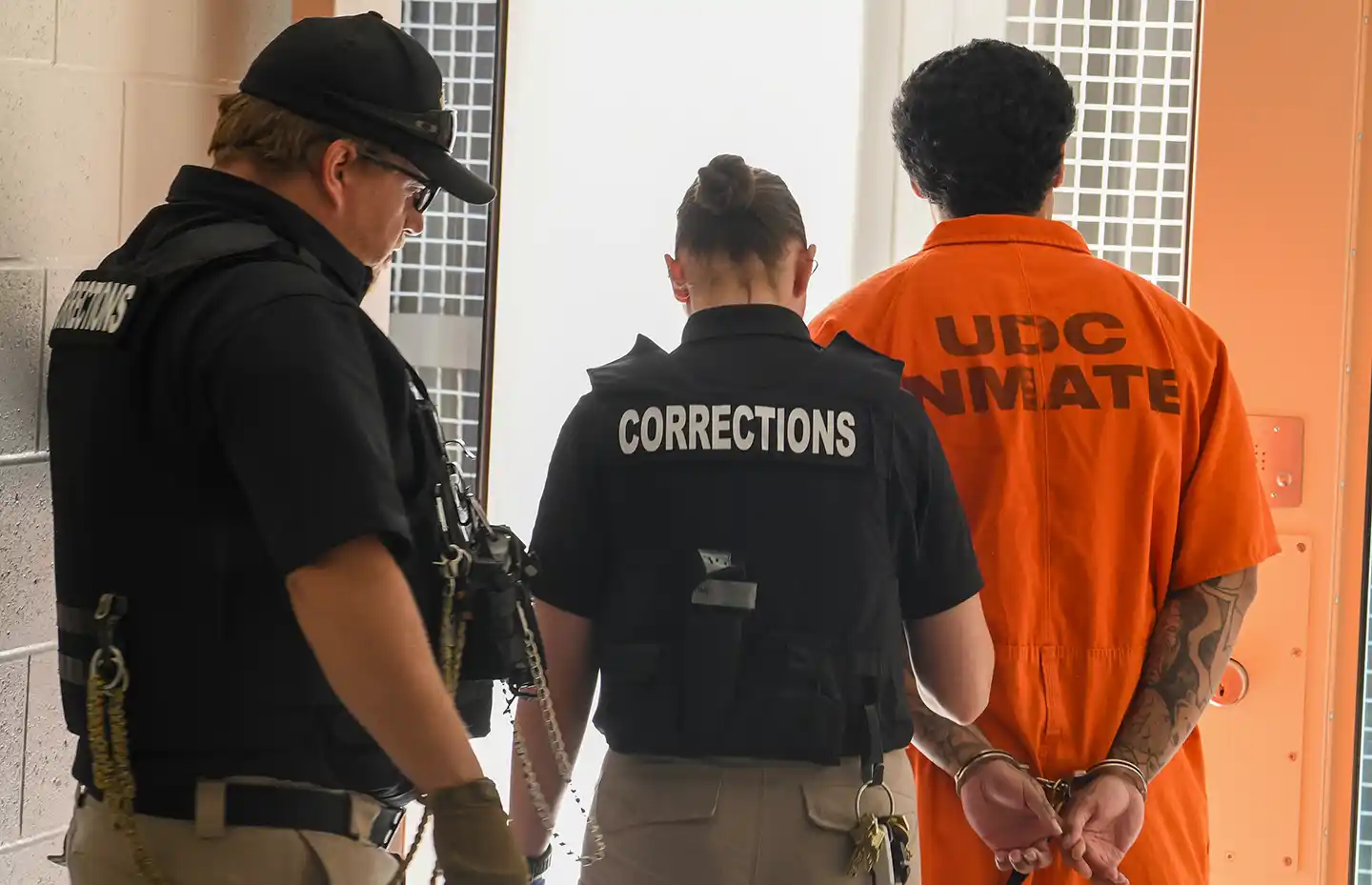 Incarcerated male being escorted by correctional officers